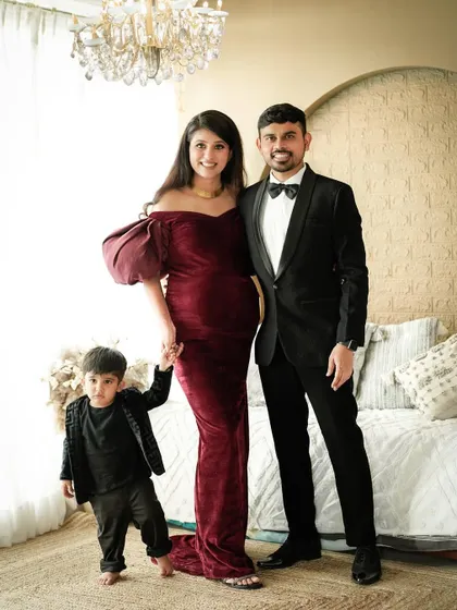 A joyful family portrait with the older brother holding his parents' hands, ready to welcome his new sibling.