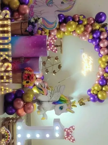 A vertical shot of the unicorn setup, showing the full balloon arch and personalized marquee letters.