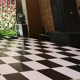 Another angle of the checkered dance floor and event setup, showing the placement of speakers and lighting equipment. We ensure all technical elements are integrated cleanly into the decor.