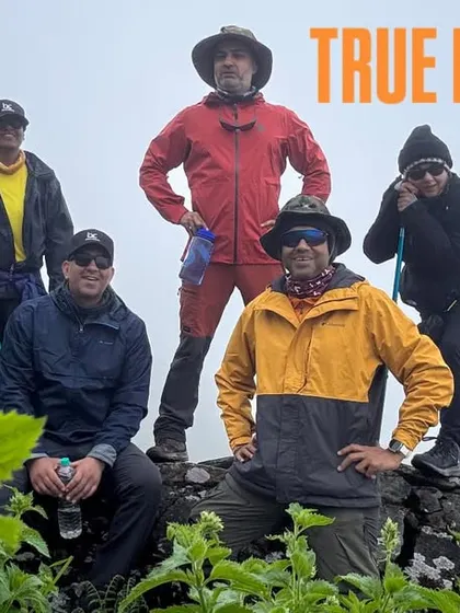 True friends are the ones who take you up on your craziest whims. A happy group of friends posing on a rock, celebrating their bond in the mountains.