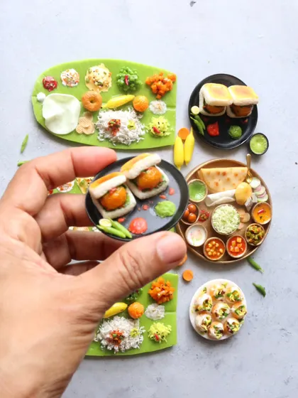 A collection of miniatures including vada pav, a North Indian thali, and several banana leaf meals.