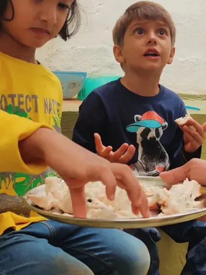 Success! The harvested fruit is shared among the children, a sweet reward for their ingenuity and teamwork.