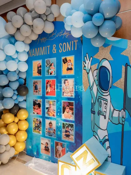 A milestone photo board with a cosmic background, celebrating the first years of the birthday twins, Sonit and Nammit.