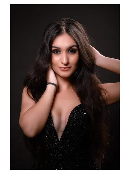 A glamorous studio portrait in a sparkling black dress. The model's pose is elegant and sophisticated.