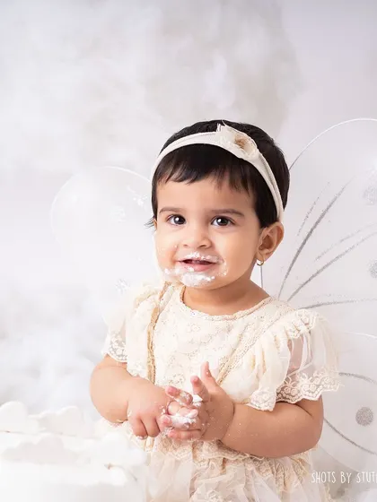 A close-up of our little fairy enjoying her cake. Her delicate features and the frosting on her face make for an incredibly sweet and memorable portrait.