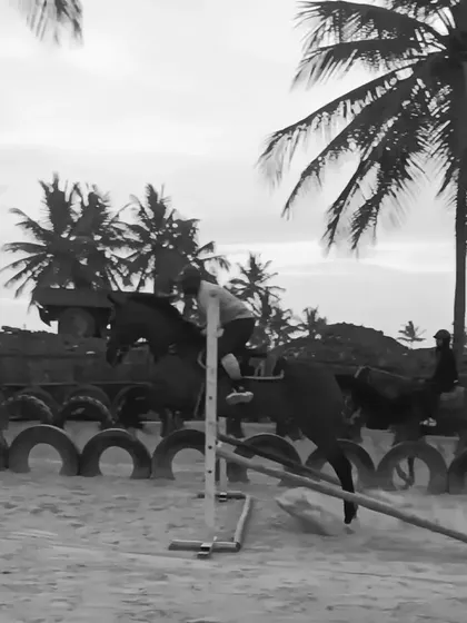 A black and white shot of a rider clearing a jump, highlighting the timeless elegance and power of the equestrian sport.