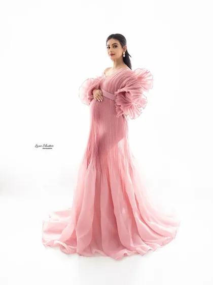 A full-body portrait showcasing the stunning silhouette created by this pleated pink gown. It’s a perfect blend of modern style and timeless elegance for your maternity photos.