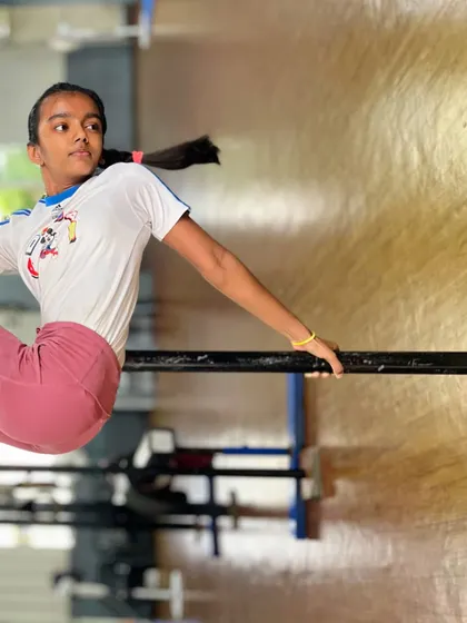 Strength, grace, and determination. This student holds a strong pose on the bars, showcasing the power and poise we develop in our calisthenics classes.