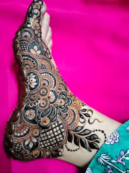 A stunning and intricate foot design that combines floral, paisley, and geometric elements with bold, dark shading for a truly unique look.