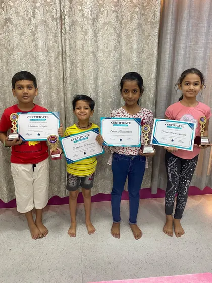 A group of our proud abacus graduates from the Charni Road branch. Each student holds a certificate and trophy, marking their successful completion of the program level.