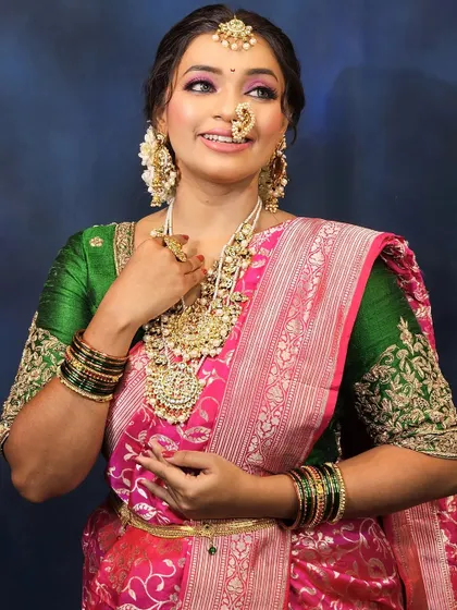 A full view of the bride, showcasing the beautiful saree, heavy temple jewelry, and the complementary makeup.