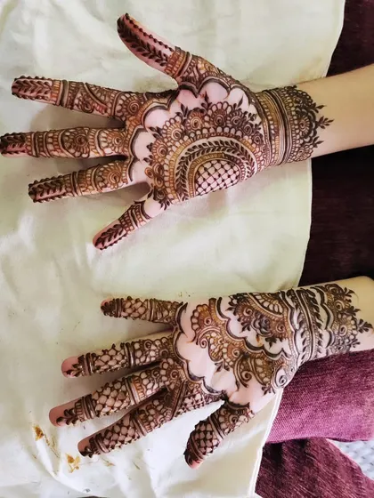 A stunning design with a central mandala and intricate patterns covering the back of the hands.