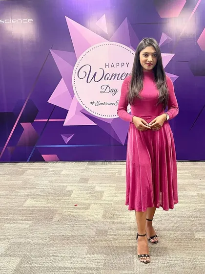 Posing in front of the 'Happy Women's Day' backdrop.
