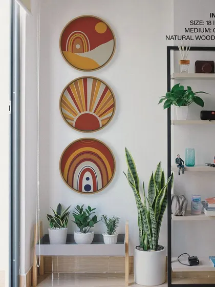A trendy set of three circular prints with bohemian-inspired sun and rainbow motifs. The warm, retro color palette and natural wood frames add a cheerful and stylish touch to this modern space.