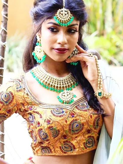 A close-up of a heavily embroidered blouse with intricate patterns. This kind of detailed work makes for a perfect statement piece to be paired with a saree or lehenga for a grand wedding look.