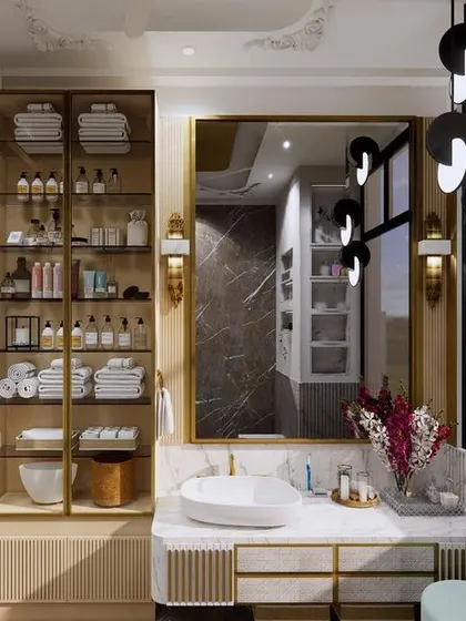This master bathroom exudes luxury with its combination of marble, gold accents, and modern lighting. The space includes a large vanity, a glass-enclosed shower, and ample storage for a clutter-free environment.