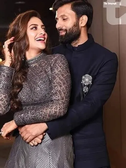 This couple's reception look is all about modern glamour. Her sparkling grey gown and his sharp navy bandhgala with a jeweled brooch create a sophisticated and stylish pair.