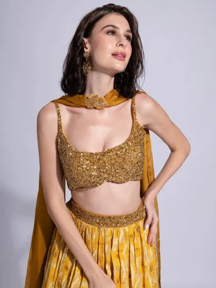 A beautiful mustard yellow lehenga paired with soft, bronzed makeup. The hair is styled in loose waves for a relaxed yet festive feel.
