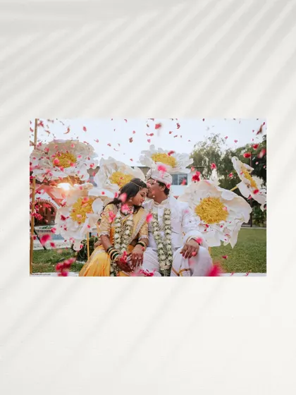 A celebratory moment captured with a creative flair. The couple is showered with flower petals, the bright colors and their loving expressions creating a joyful and artistic photograph.