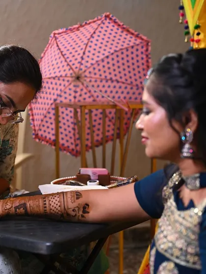 A candid shot of me applying a detailed design to a bride's arm. My focus is always on creating flawless and beautiful art.