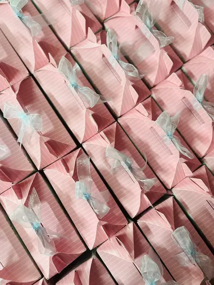 An angled shot of the pink favor boxes, highlighting the delicate organza ribbon tied on each one.