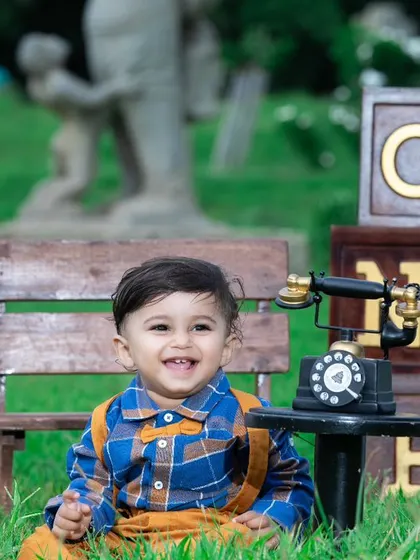 This little one is enjoying his birthday celebration in the park, surrounded by vintage props.