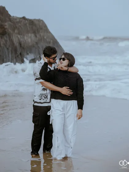 A romantic pose in the shallow waves of the ocean, the couple embracing as the water swirls around their feet.