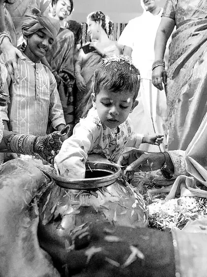 A beautiful black and white candid of a child playing during a wedding ritual. The innocence of the child contrasts beautifully with the ancient traditions.