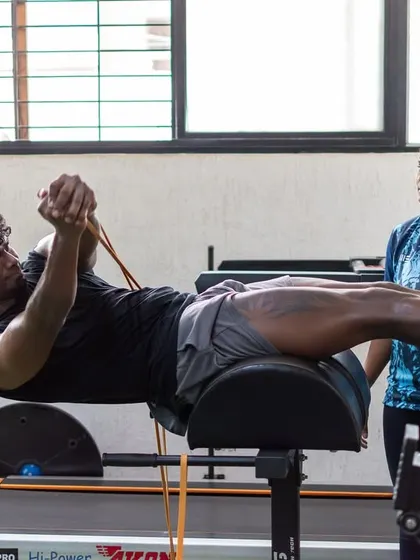 A client performs a glute-ham raise, a key exercise for building posterior chain strength and preventing lower back issues.
