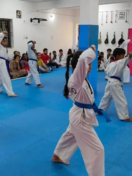 Blue belt students practicing an upper block during their Poomsae.