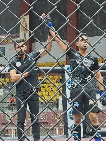 Another angle of a well-deserved victory in the octagon. The referee raises our fighter's hand, marking a successful bout.