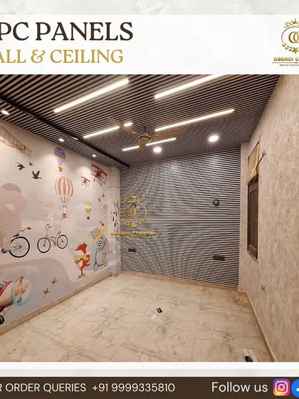 In this kid's room, I used WPC panels for both the wall and the ceiling. This adds texture and durability to the space, perfectly complementing the custom wallpaper on the adjacent wall.
