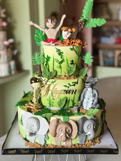 Welcome to the wild side! This jungle-themed cake is roaring with flavor, featuring adorable, handcrafted fondant animals like elephants, monkeys, and lions, perfect for a little explorer's party.