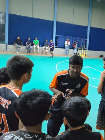 A coach talking strategy with his players during a timeout. Communication and guidance are key parts of our coaching philosophy.