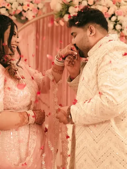 The groom gently kisses his fiancée's hand after placing the ring on her finger.