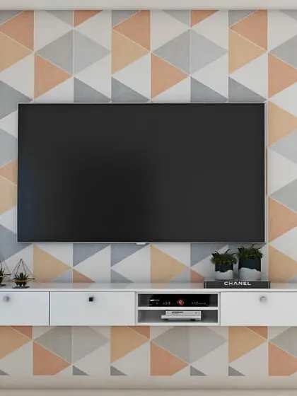 This simple floating white TV console is mounted on a wall with a playful geometric triangle pattern. It's a great example of how a basic furniture piece can be elevated by the wall treatment behind it.