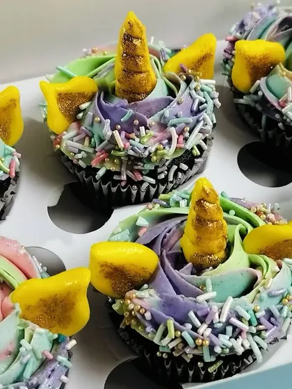 Another detailed shot of the unicorn cupcakes, highlighting the texture of the buttercream and the generous amount of pastel sprinkles. These mini cupcakes are filled with a rich chocolate ganache.