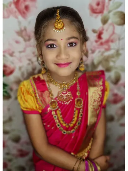 A straight-on portrait of this little stunner, showing her complete look with the bindi, maang tikka, and beautiful necklaces.
