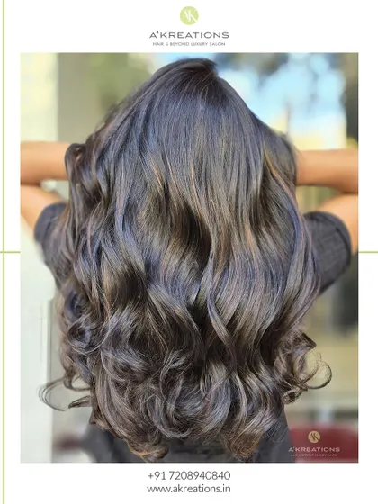 Sweet caramel brown highlights styled into glossy waves, giving the hair a healthy and vibrant glow.
