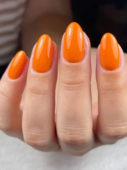 A bold and bright orange manicure. This glossy, cheerful color is sure to make you smile every time you look at your hands.