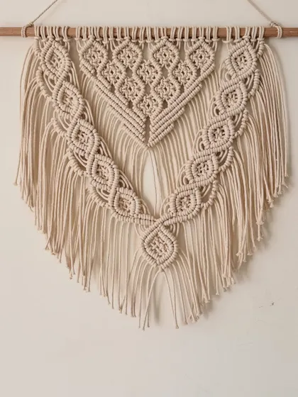 A beautiful, classic macrame wall hanging made for a lovely client. The natural cream color and intricate diamond and braid patterns make it a versatile piece that adds a touch of handmade elegance to any room.