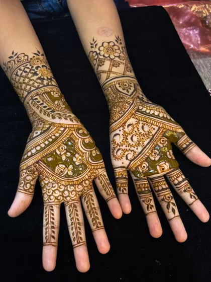 A full bridal design with a mix of styles. The right hand features geometric checks and floral patterns, while the left incorporates more traditional Indian motifs.
