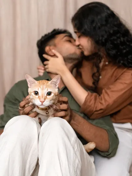 "My Hoomans are getting Married!" This creative shot of Toffee the cat with his parents kissing in the background is a playful and heartwarming way to announce an engagement.