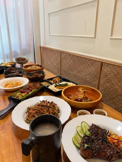 Another angle of our New Year's feast, showing the long table filled with bowls of curries, noodles, rice, and appetizers. There's always something for everyone.