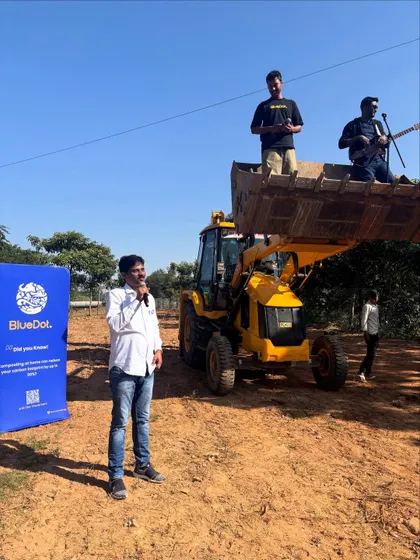 The BlueDot tree-planting drive opens with people gathered by a JCB, before the community's work on this open site.