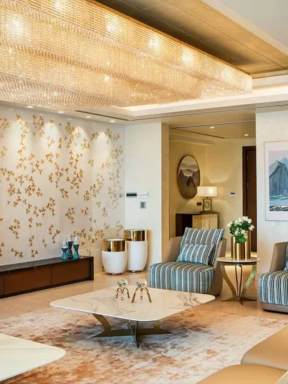 For the formal living room in the Kingfisher Tower project, we designed a space of pure opulence. A massive crystal chandelier illuminates the room, which features custom wallpaper, bespoke furniture, and a curated collection of art, all working together to create an atmosphere of grand luxury.