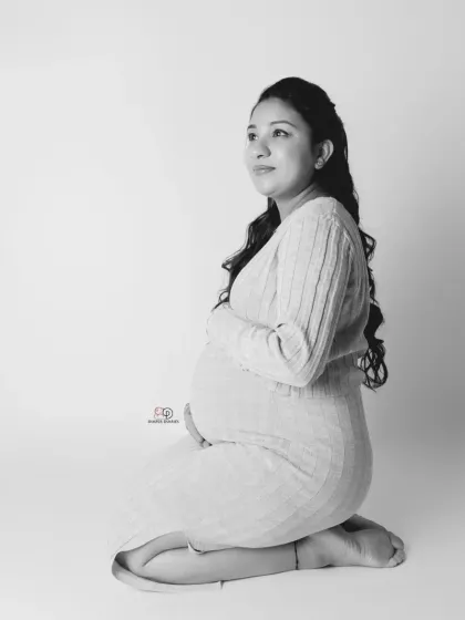 A beautiful, serene moment captured in a high-key black and white style. This minimalist approach results in a timeless and elegant maternity portrait.