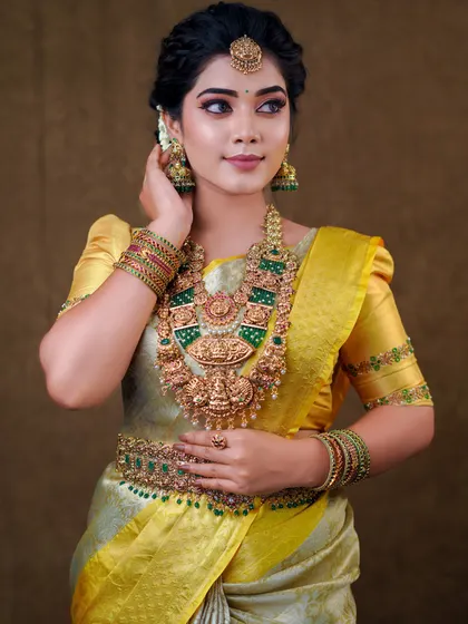This silver and yellow silk saree creates a unique and elegant look. The draping is done to show off the beautiful contrast border and the richness of the silk.
