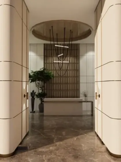 A symmetrical view of the lobby entrance, where curved, paneled walls guide you into the space. The design uses a neutral palette and a striking central light fixture to create a sense of balanced elegance.