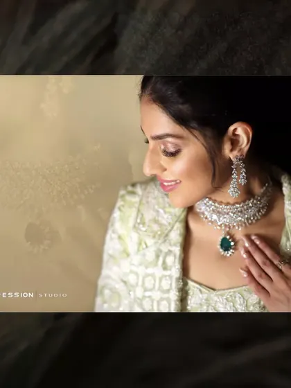 A beautiful bridal portrait focusing on the stunning diamond and emerald necklace, highlighting the elegance of the bride's attire.